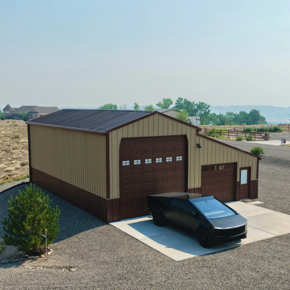 Steel garage with a covered side bay and a truck parked outside